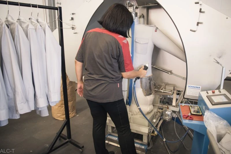 Mitarbeiterin beim trocknen von Hemden